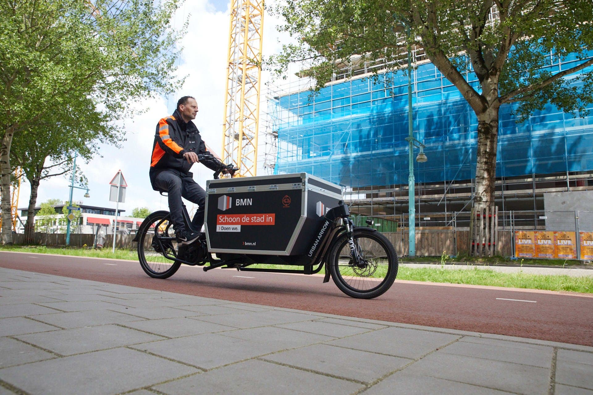 Servicemonteur op een elektrische Urban Arrow cargobike voor BMN bij stedelijke werkzaamheden